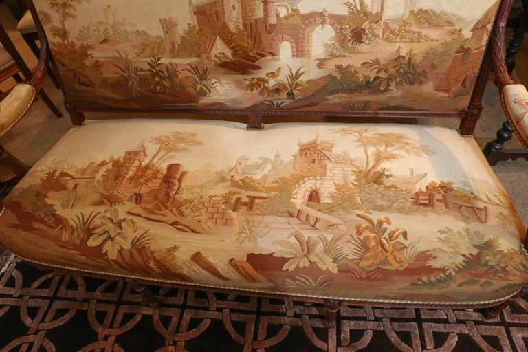 Un grand salon composé d'un canapé, de quatre fauteuils et d'une chaise latérale.
Chacune d'entre elles est finement détaillée avec un cimier centré sur une branche et une couronne de baies nouées par un ruban.  pendentif au-dessus d'une garniture à