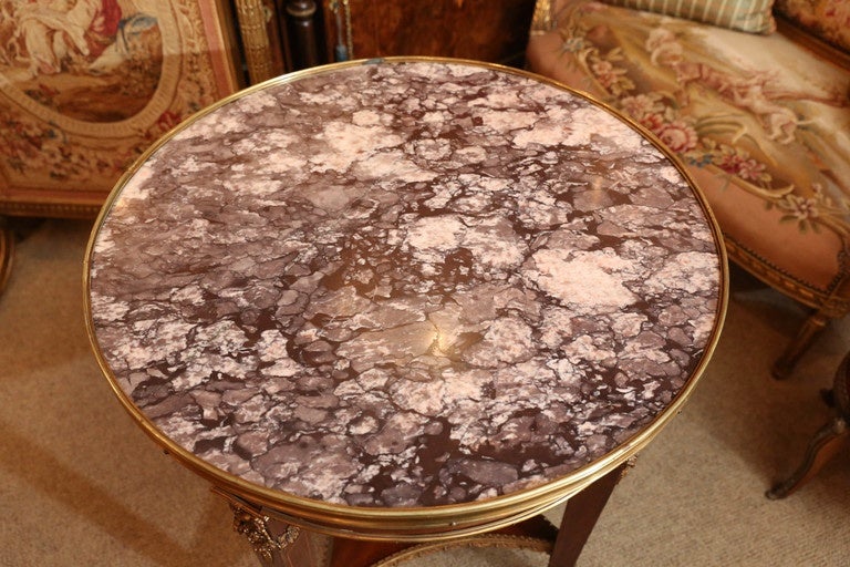 French gueridon mahogany table with gilt bronze mounts,
The circular marble top in Rose beige color rests on a frieze
Which encloses one drawer. The tapering rectangular legs
Have bow appliqués in gilt bronze.
