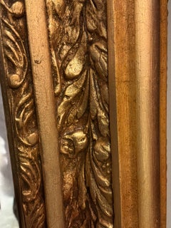 Pair of French gilt mirrors with a bow design at the crest