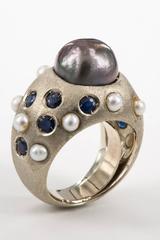 Bague : perle noire sur or blanc brossé avec saphirs