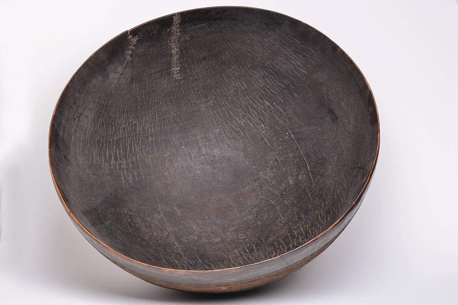 This large Tuareg bowl was carved off a single piece of wood, with incised geometric patterns around the exterior. The Tuareg are nomads living in the Saharian region of Northern Africa. They create beautiful carved bowls, light and easy to pack for
