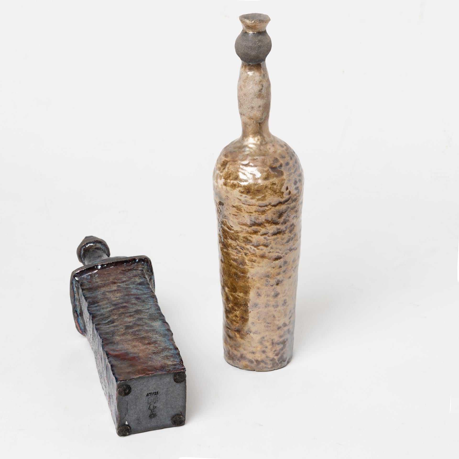 Bouteilles en céramique Raku, l'une en bronze clair h.44,7 x base 9 cm, l'autre plus foncée. 
h.39,6 x base 8x8. 
Magnifique côte à côte sur un buffet mais aussi sur une bibliothèque.
Je recommande de ne pas les soulever du cou, car la céramique