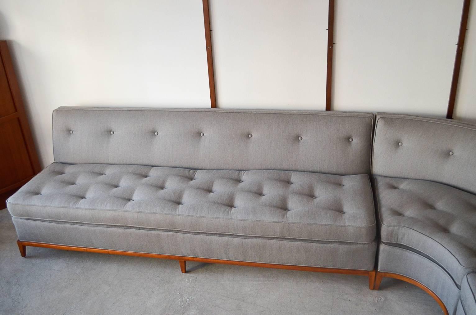 Three-piece sectional sofa by T.H. Robsjohn-Gibbings for Widdicomb. Walnut base with newly recovered double sided cushions with clips to prevent cushions from traveling.

Lovely updated grey herringbone tweed fabric with tufted backrest and double