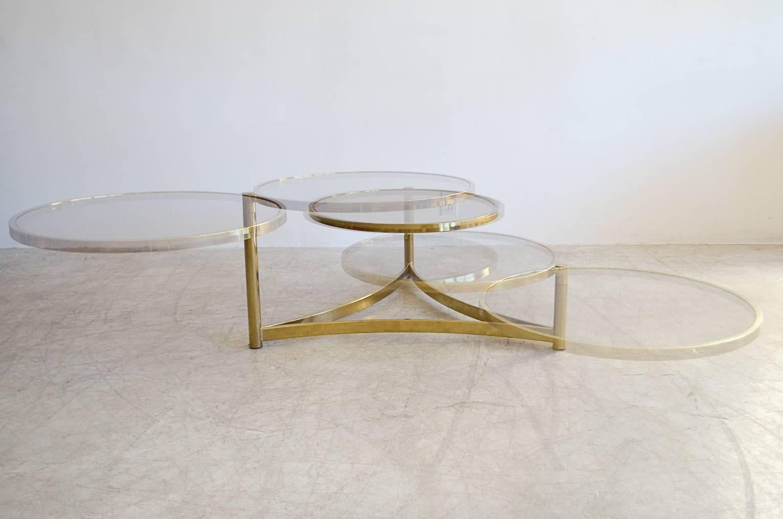 Beautiful tri level brass and glass swivel coffee table with lightly smoked glass coffee table with designer triangle base.  Allows for a more sturdy base when round tiers are extended.  See additional photos.

Brass is in excellent condition and