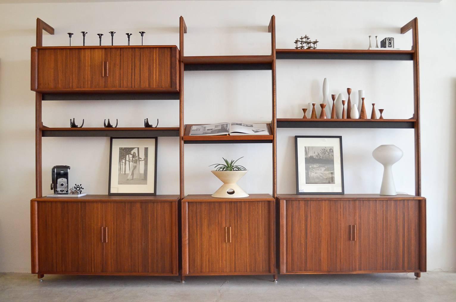 Beautifully restored walnut four bay wall unit (only 3 bays are photographed, an additional wall bracket is available to expand to 4 bays) by Barzilay. Includes four beautiful tambour door cabinets with all included hardware.

Cabinets all have