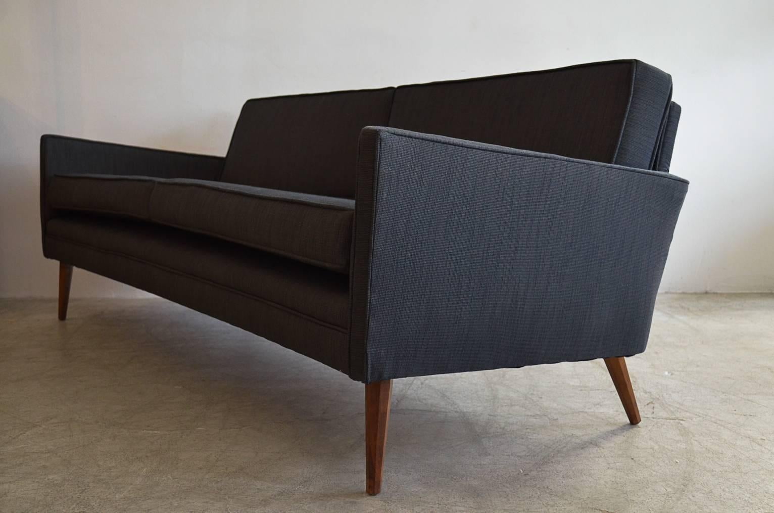 Iconic and rare sofa by Paul McCobb with signature thin angled arms and slight curved back. Beautiful black tweed fabric and walnut legs.

Measures: 80
