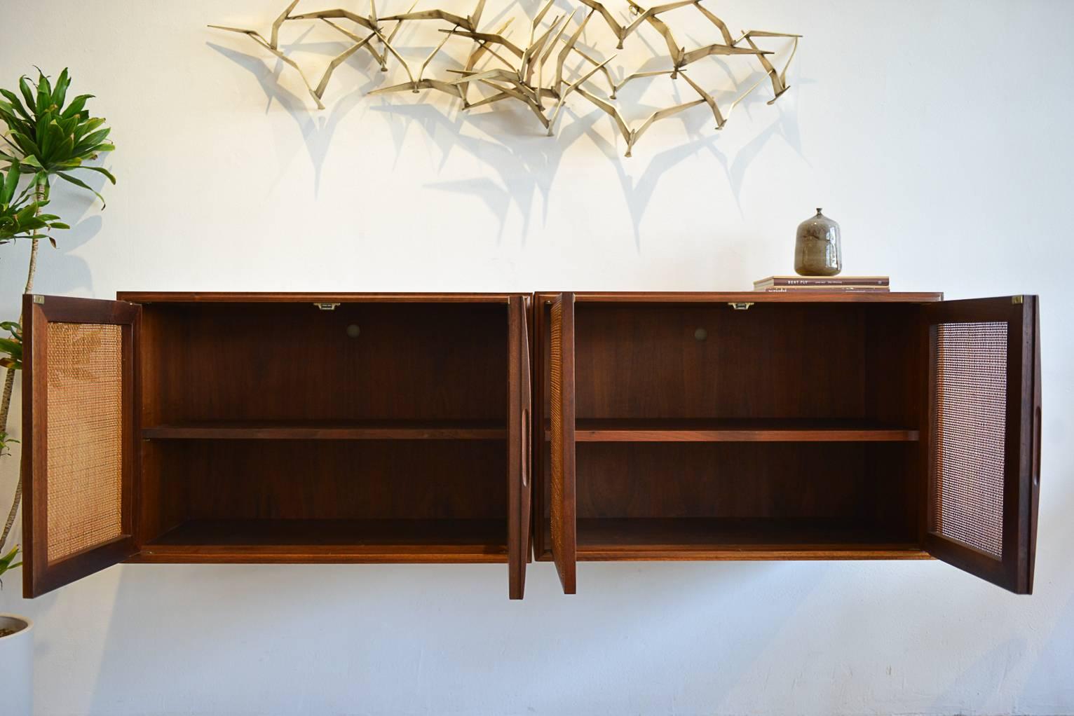 Beautiful walnut and cane front floating wall-mounted cabinets with inner adjustable shelving. Originally from the Palm Springs estate of Zsa Zsa Gabor. Fully restored walnut. Cane is original, some wear, as shown in photos.

Each cabinet measures