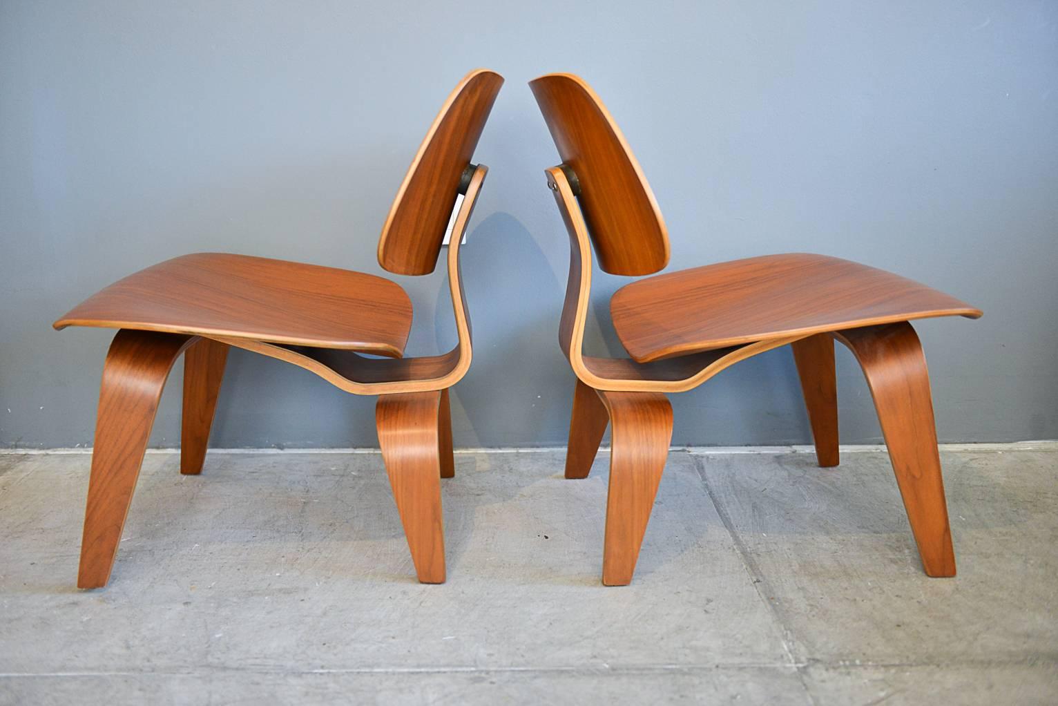 Beautiful and matching pair of Charles Eames LCW lounge chairs with great honey patina. Excellent original condition, circa 1980s. Hardly used with original screws and feet. One chair has had oval back shock mount replaced, otherwise excellent.