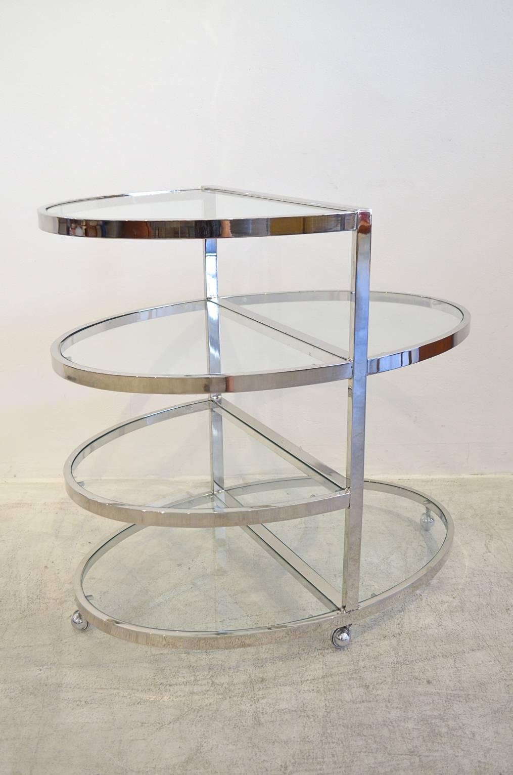 1970s chrome and glass rolling bar cart. Chrome is in good condition, glass has minor chips on two shelves, otherwise very good.

Measures: 30