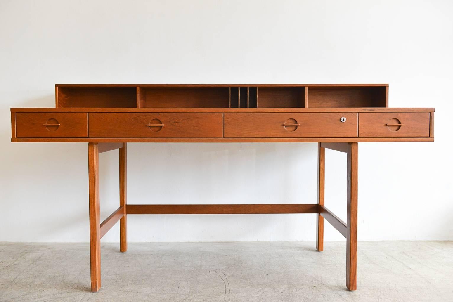 Fully restored beautiful Danish modern Teak flip-top partner’s desk by Jens Quistgaard for Peter Løvig Nielsen. Beautiful sculpted pulls and unique flip-top shelf flips down to extend the desk for more working space and can be used as a partner’s