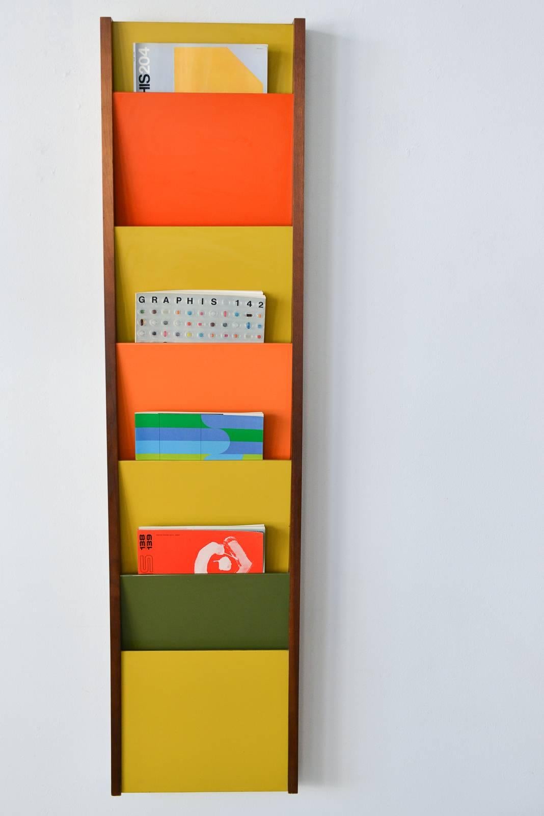 Rare multi-colored wall-mounted magazine rack/holder by Peter Pepper Products of Wilmington, CA, circa 1970. Excellent vintage condition, walnut frame with laminate dividers in orange, green and mustard. Measures: 57