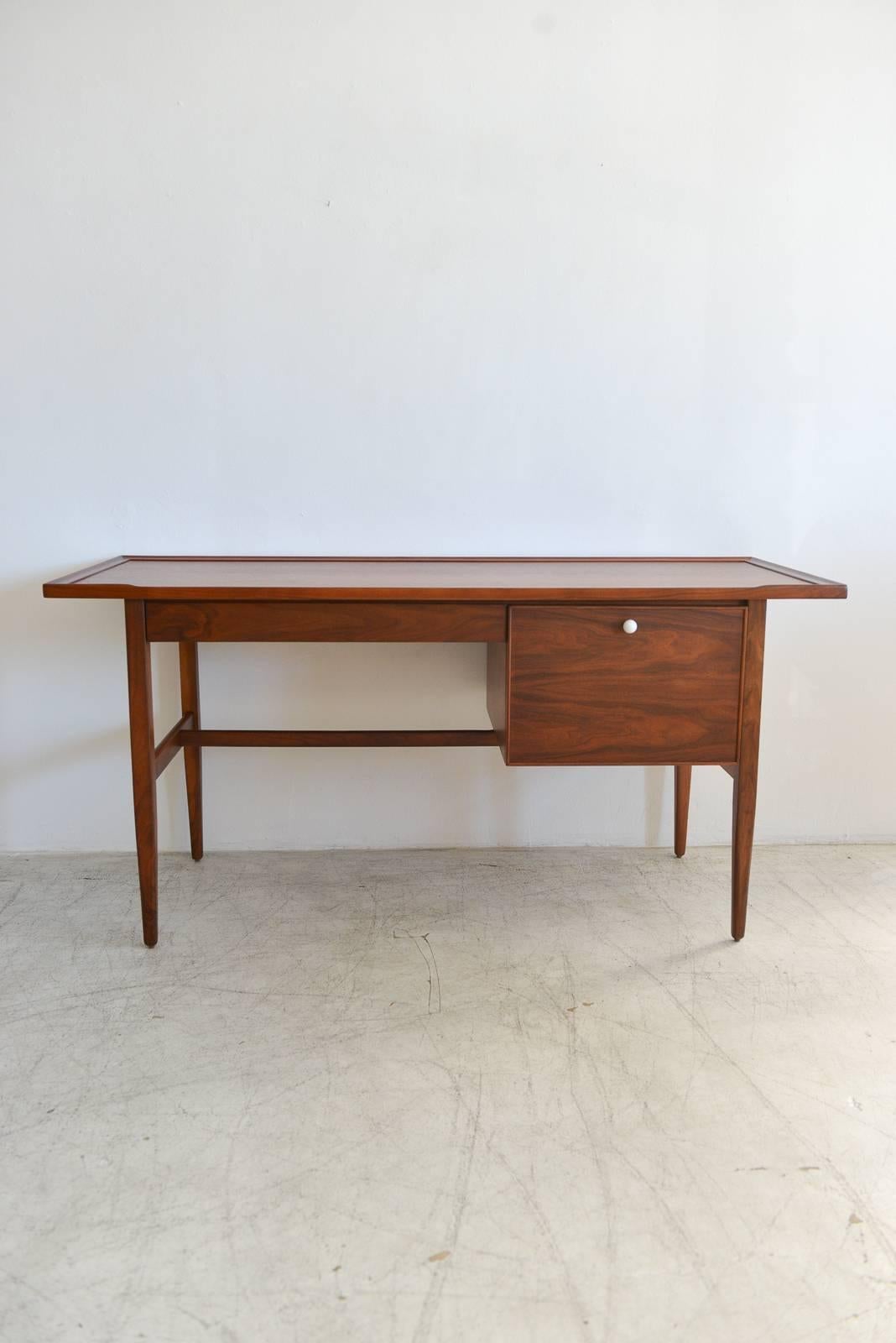 Beautiful walnut desk by Kipp Stewart for Drexel Declaration. Original porcelain hardware and sliding interior drawer (rarely do you find these). Refinished to showroom perfect condition ready for your home office or guest room.

Measures 60