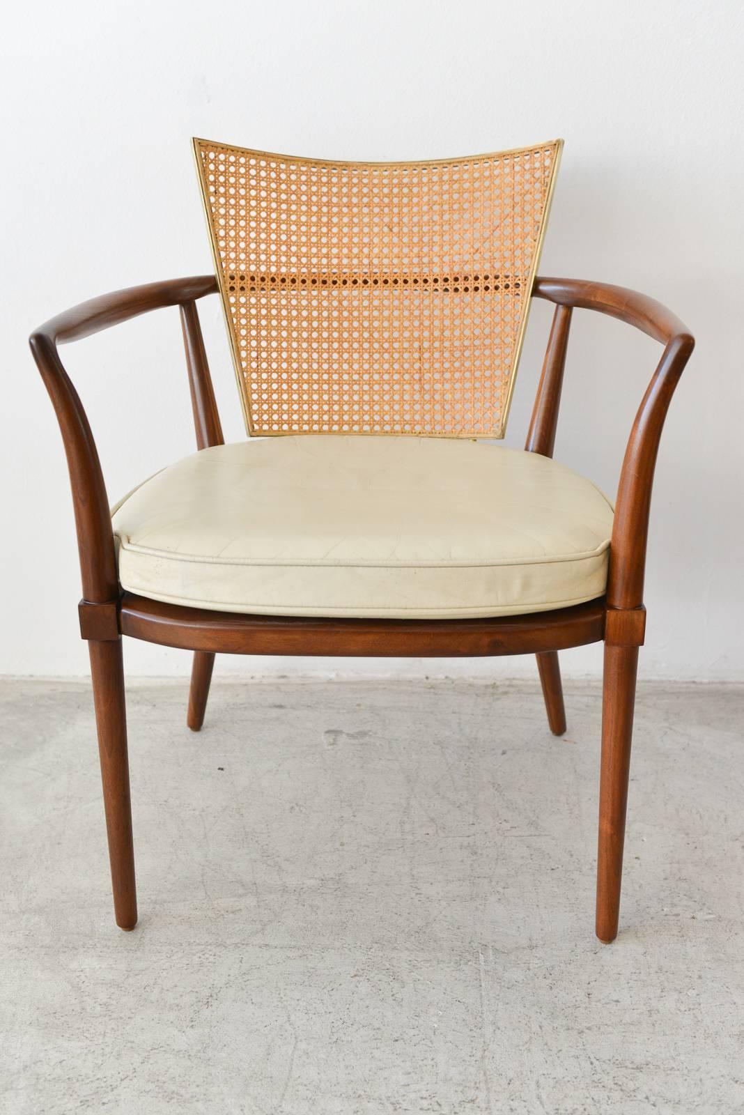 Walnut, cane and brass armchairs by Bert England. Beautifully restored walnut in showroom condition. Beautiful cane backs in excellent condition with no breaks. Brass is clean and polished. All chairs have been recovered in new Ivory leather in