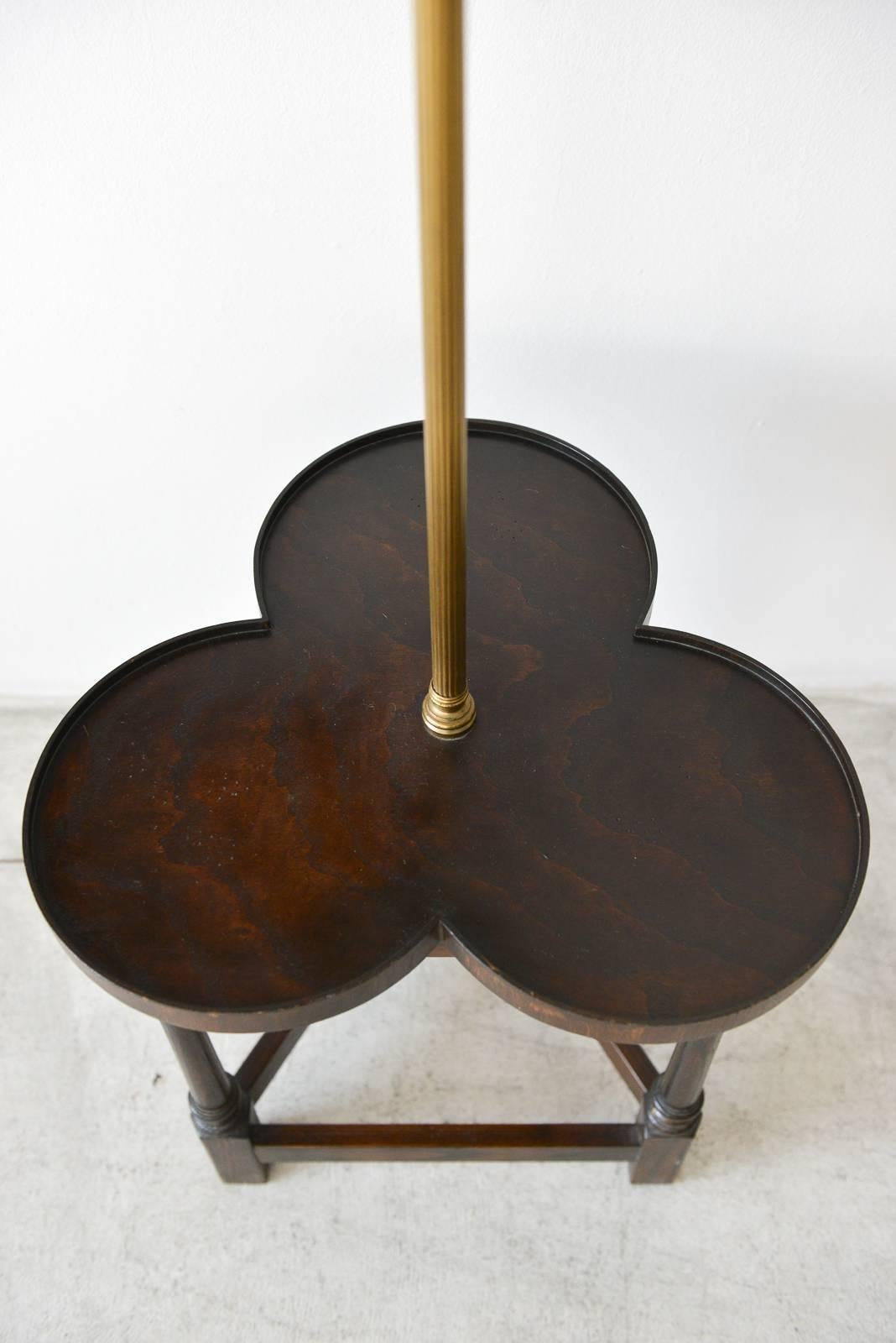 Tripod base clover floor lamp with table by Frederick Cooper, circa 1950. Beautiful rich wood with clover shaped table and tripod base. Decorative brass neck with original shade and brass finial. Original wiring, working condition with original