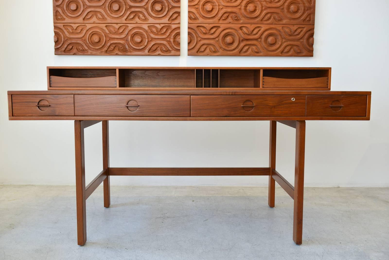 Fully restored beautiful Danish modern teak flip-top partner’s desk by Jens Quistgaard for Peter Løvig Nielsen. Beautiful sculpted pulls and unique flip-top shelf flips down to extend the desk for more working space and can be used as a partner’s