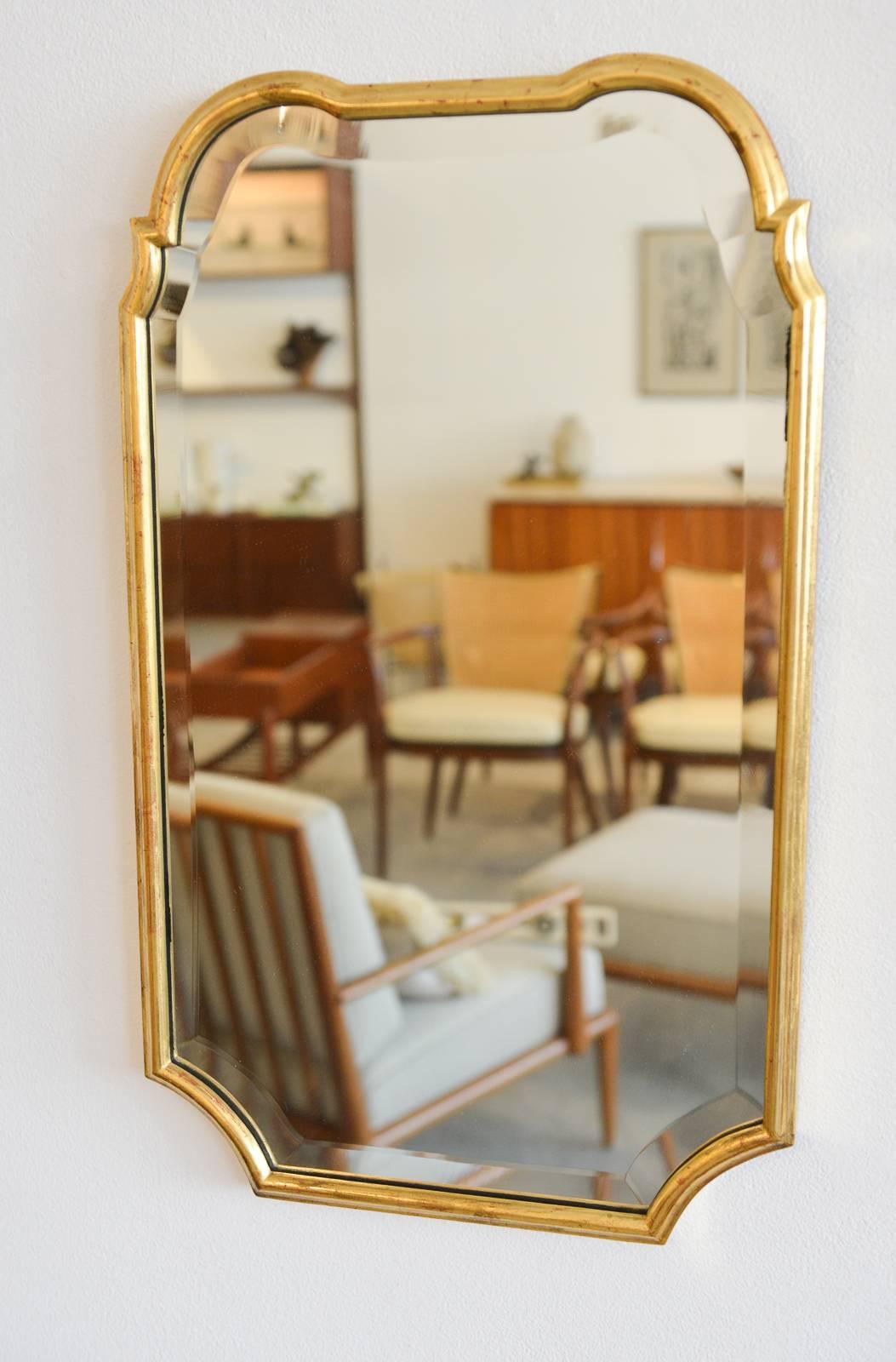 Friedman brothers gold gilt mirror, circa 1960. Original 22-karat gold finish, bevelled edges. Excellent condition with no chips or cracks. Retains original Friedman Brothers Decorative Arts, Inc. label on reverse.

Measures 25" H x 15"