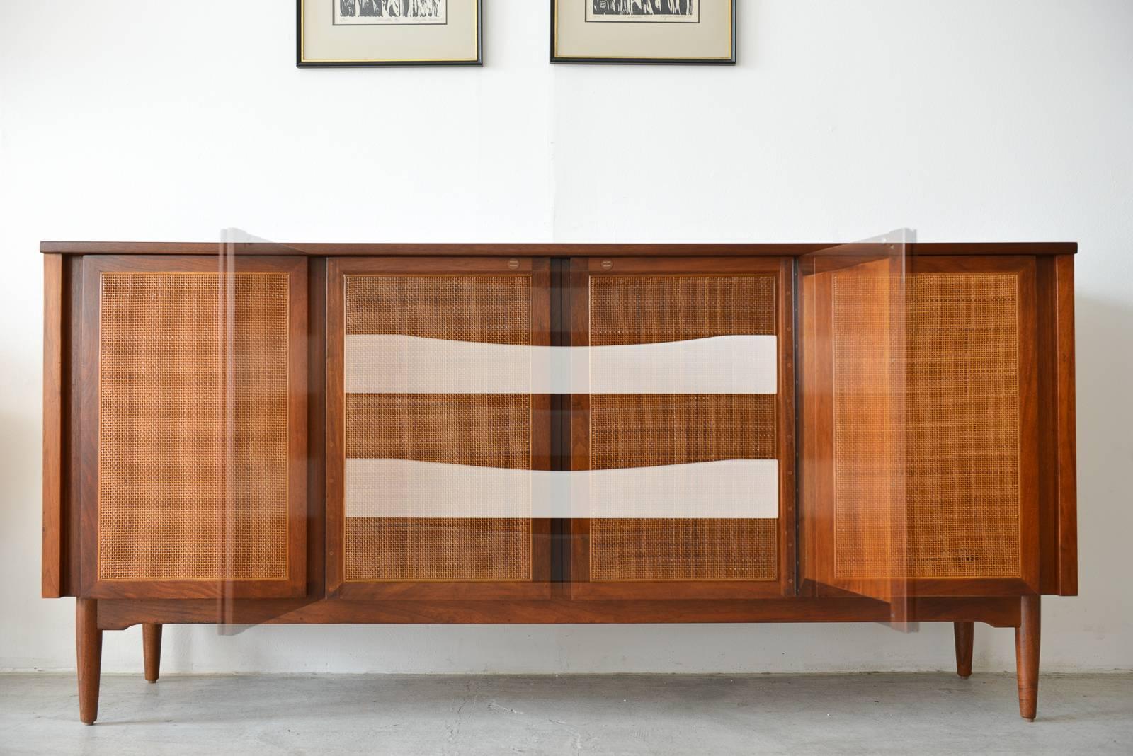 Beautiful walnut and cane front door credenza with updated black and white inner drawers. Both side have an adjustable shelf. Finished on the reverse.
Showroom condition.

Measures 64