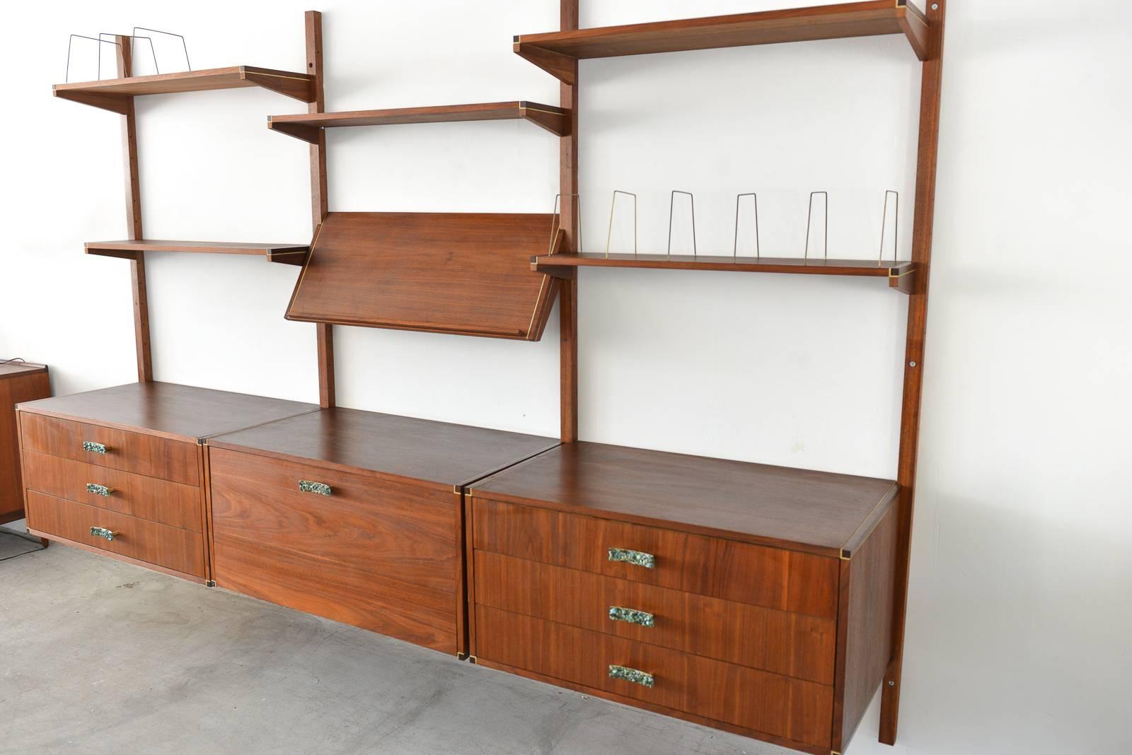 Walnut and brass shelving wall unit by Gerald McCabe, circa 1970. Beautiful walnut grain and unique rare brass finishes (as opposed to the brushed aluminium, which is common) unique precious stone inlay with brass hardware. All single shelves have