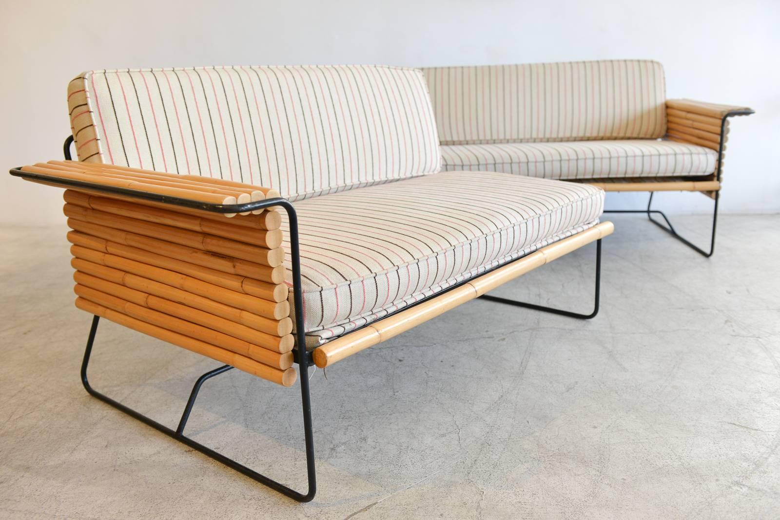 Rattan and wrought iron seating ensemble by Herb and Shirley Ritts for Ritts Co., Los Angeles, circa 1955. Full set included two-piece settee or loveseat, lounge chair and matching side table. Made of heavy wrought iron with rattan accents, this is