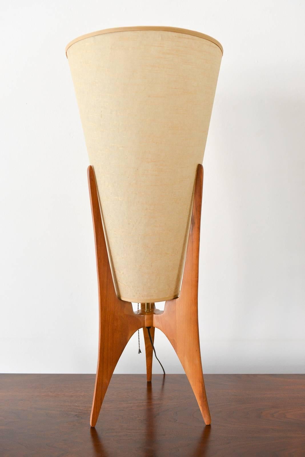 Atomic tripod table lamp with original grasscloth shade, circa 1959. Wood base with brass detailing and original grasscloth shade. Original wiring, working condition. 

Available to see in our Modern Vault Showroom, 361 Old Newport Blvd, Newport
