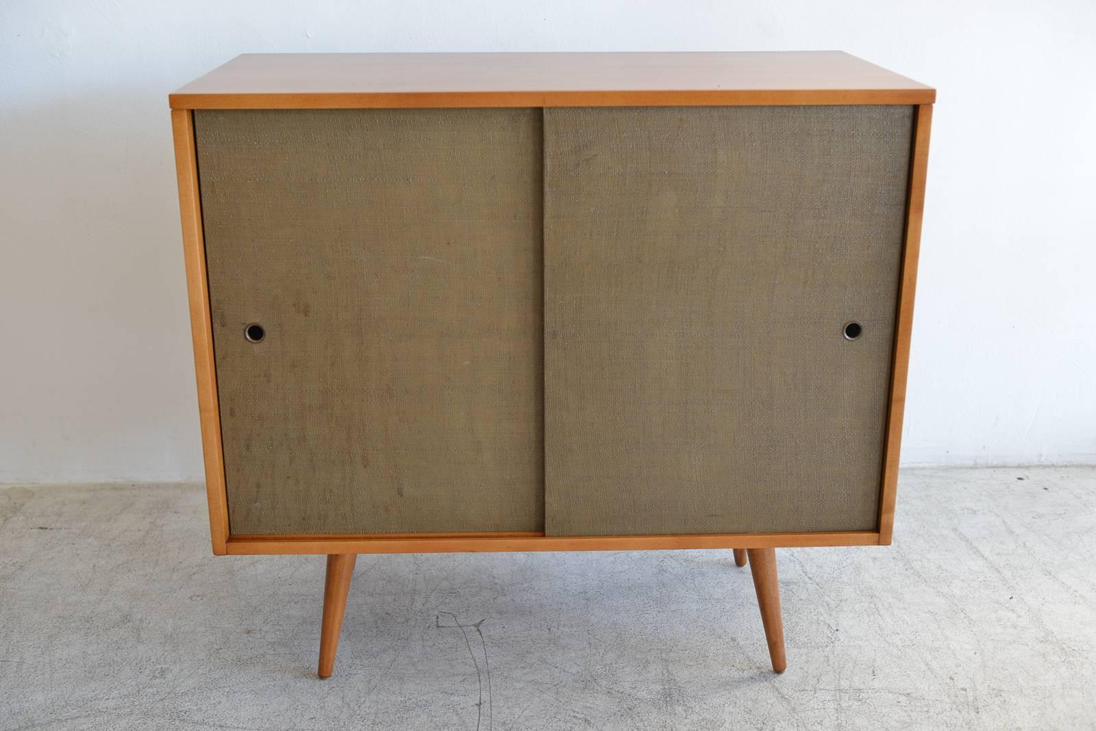 Paul McCobb Planner Group large cabinet, circa 1955. Maple with original grass cloth sliding doors. Perfect by itself or as a compliment to the smaller cabinet available in a separate listing. Professionally restored wood in showroom condition.