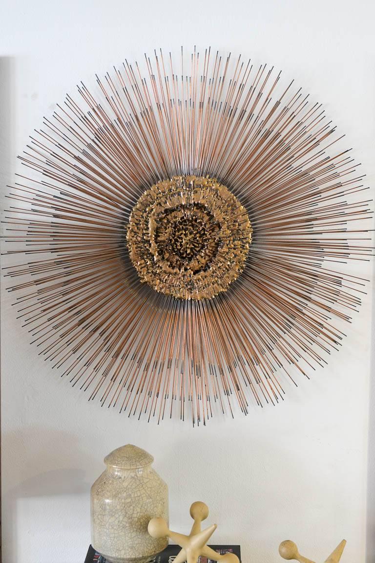 Sunburst wall sculpture, circa 1975. In the manner of Frederick Prescott, beautiful Brutalist style with brass and copper detailing, excellent vintage condition. Three concentric layers of circles with varying length of sunburst rays. Excellent