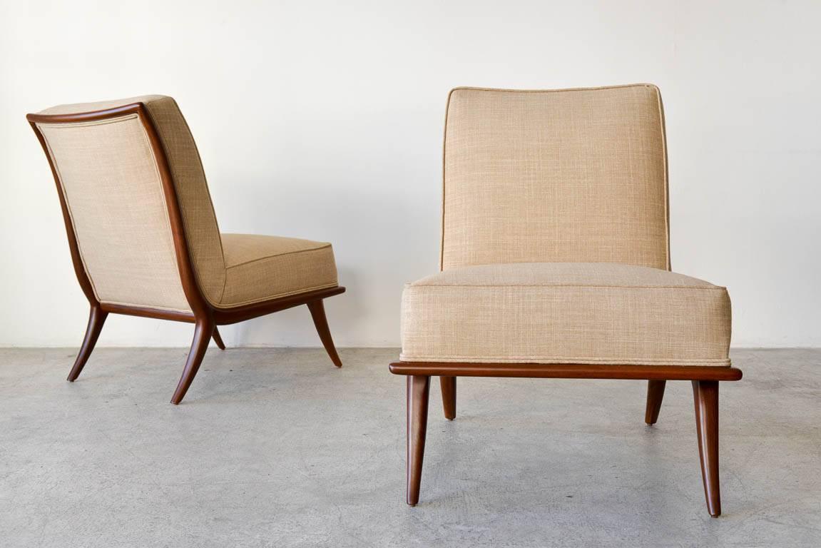 Pair of T. H. Robsjohn-Gibbings walnut sabre leg slipper chairs, circa 1950. Fully restored walnut frames with new tan tweed upholstery and foam. Classic sabre leg design considered one of Gibbings most popular and elegant chairs.  

Showroom