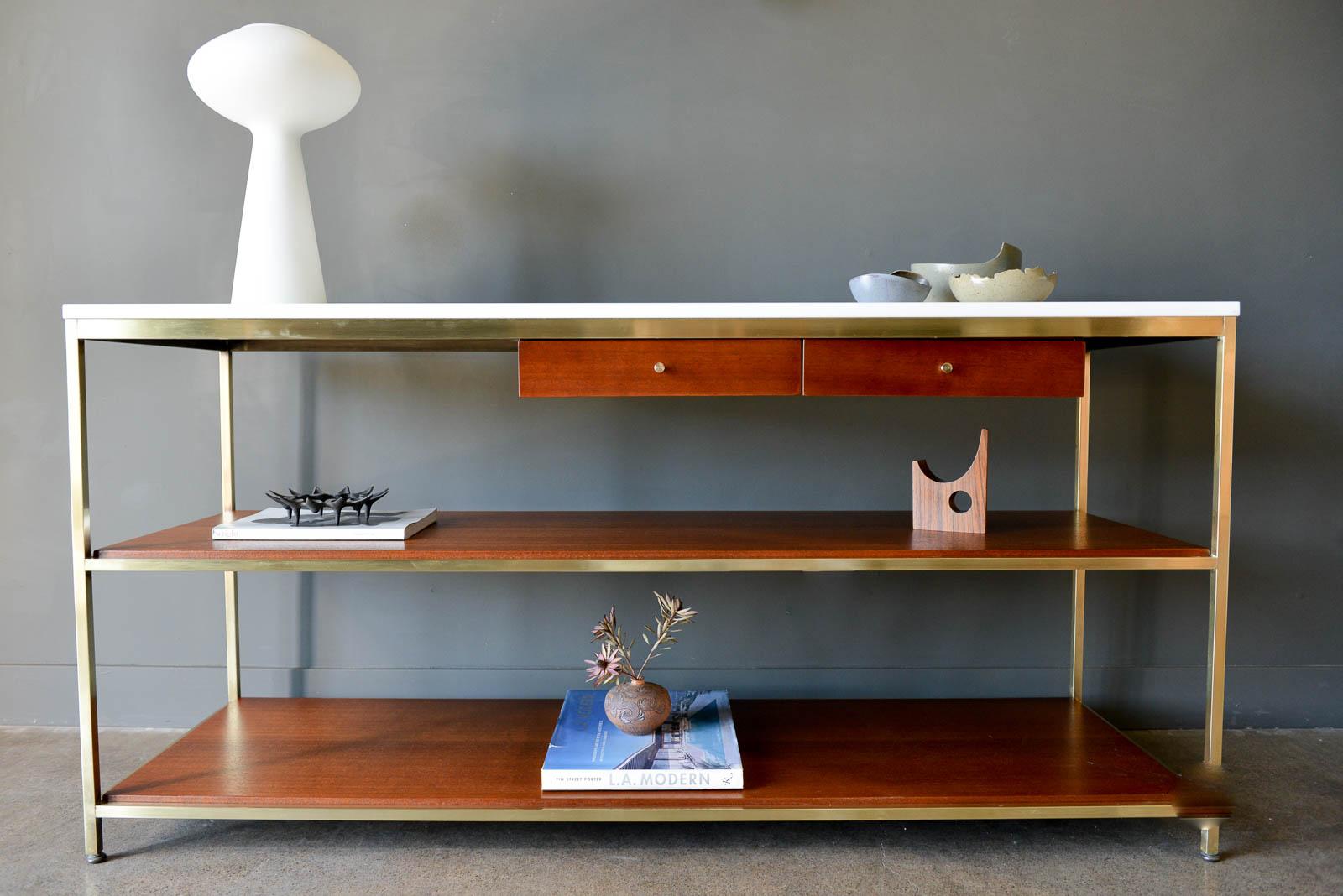 Paul McCobb brass, mahogany and vitrolite glass console table, circa 1955. From the McCobb Irwin collection, this piece features the original vitrolite glass top in excellent original condition with no chips or cracks. Brass has been polished to a