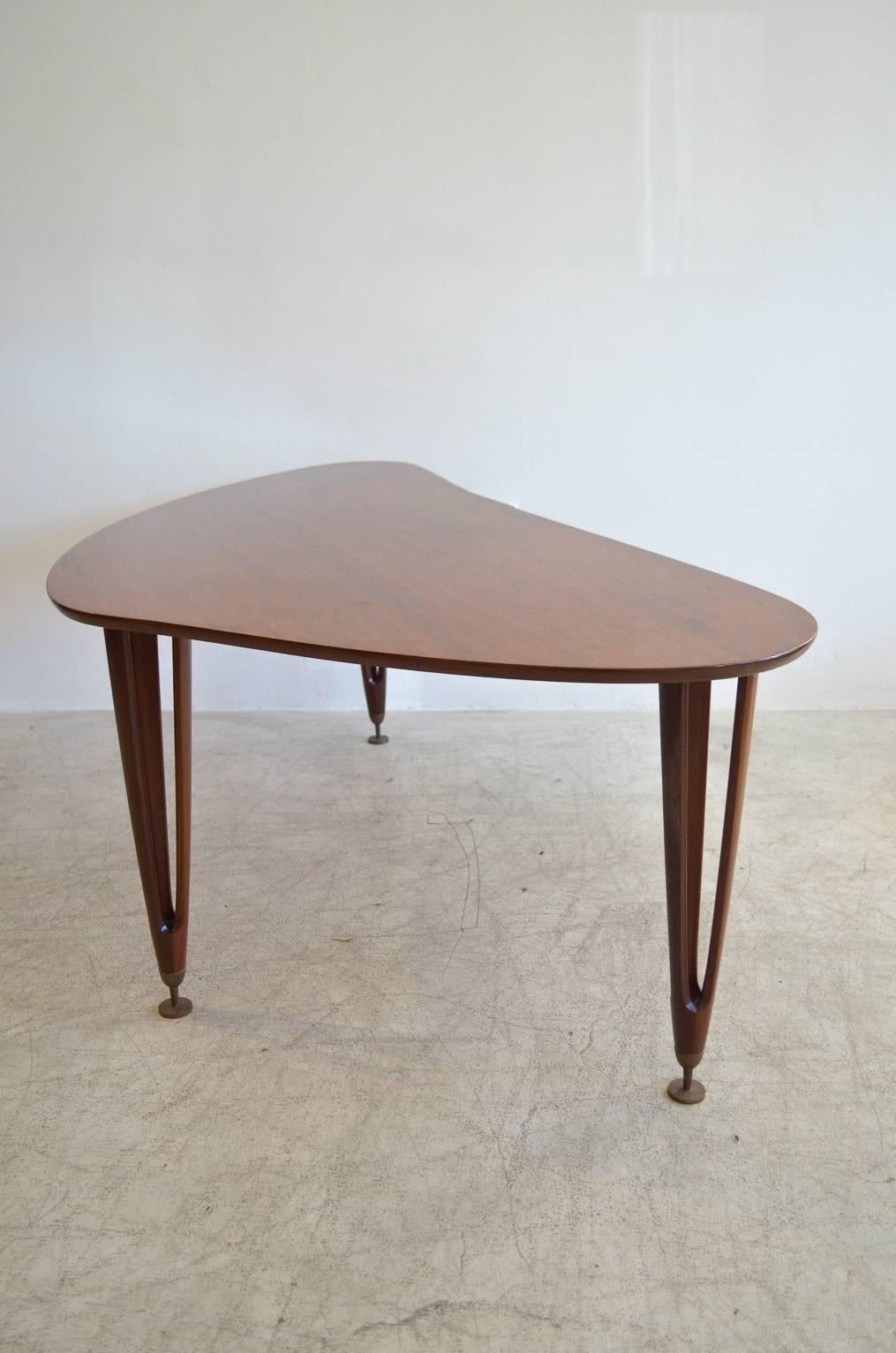 Walnut boomerang coffee table with sculpted legs, tipped in adjustable brass leveling legs. Hairpin walnut sculpted tripod legs. Made by BC Mobler of Denmark.

Excellent vintage condition with hardly any wear.  Available to see in our Modern Vault