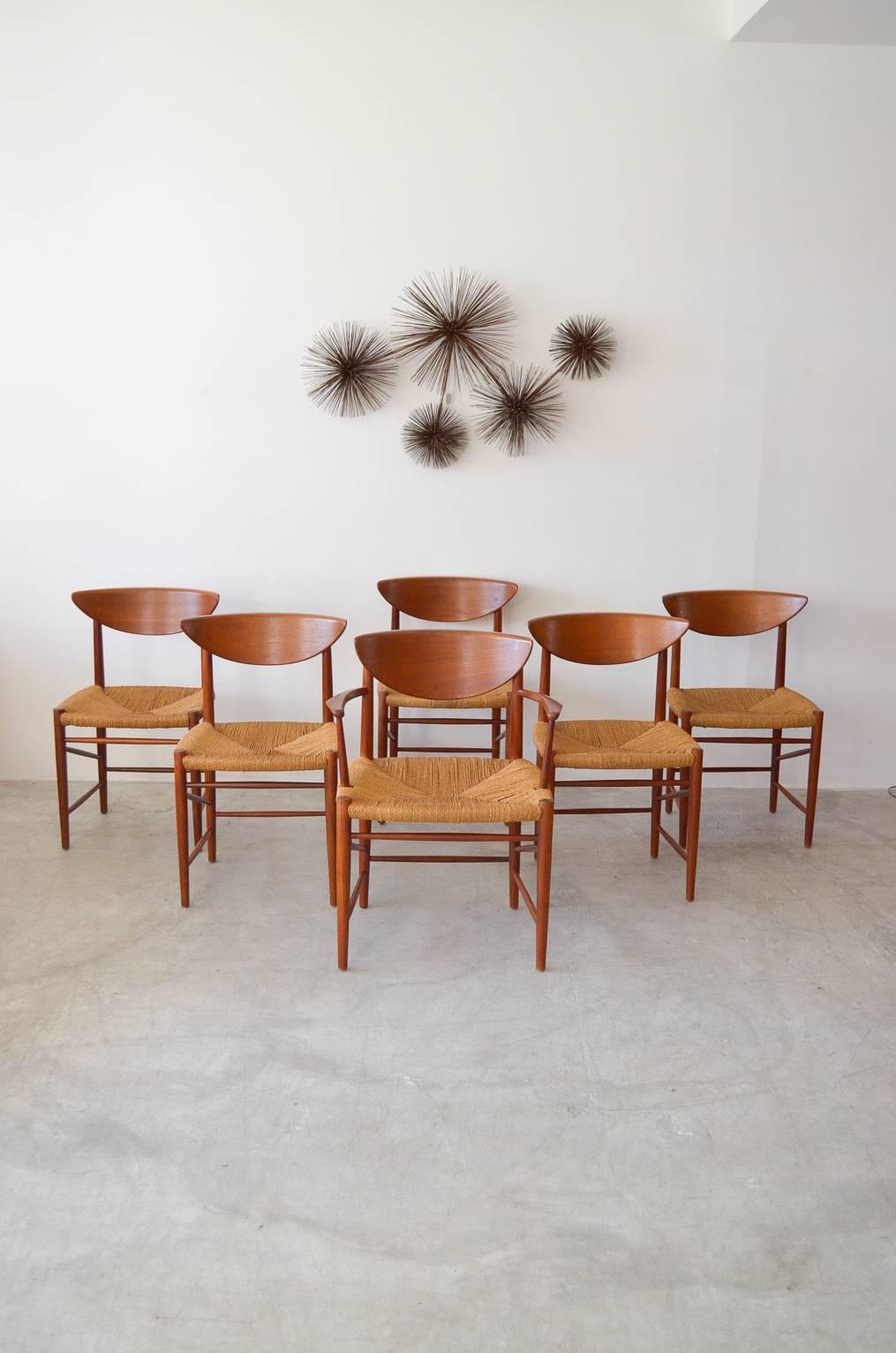 Original set of six dining chairs includes five side and one Captains chair, model 316 by Peter Hvidt & Orla Mølgaard Nielsen. Original paper cord woven seats in good condition. Sculpted teak backrests with exposed joinery. Classic and beautiful