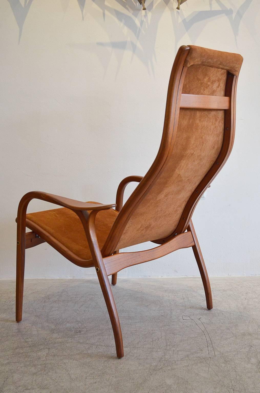Elegant Yngve Ekstrom Lamino chair with new suede upholstery and refinished wood. Pristine showroom condition, early model with brass detailed hardware. Elegantly done in beautiful carmel suede.

Measures: 27.5
