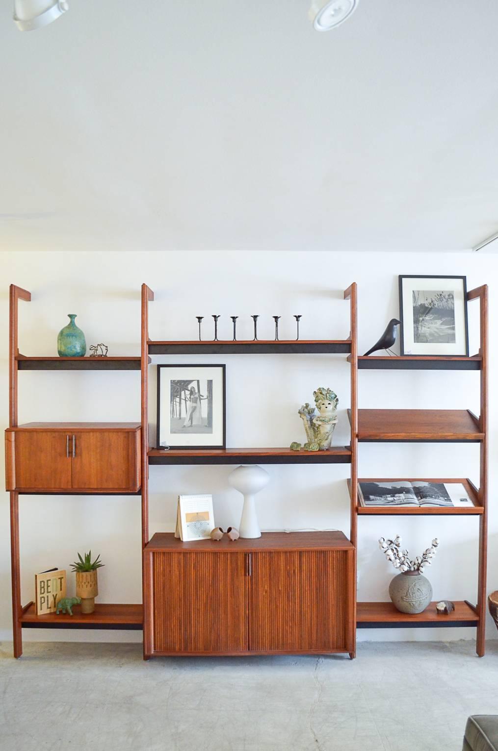 Versatile 3 bay 'Multispan' walnut shelving or wall unit by Barzilay.  Three bays, unlimited options to configure.  Includes all hardware, 6 shelves, 2 magazine shelves, one large tambour door cabinet and one small upper cabinet.

Fully assembled