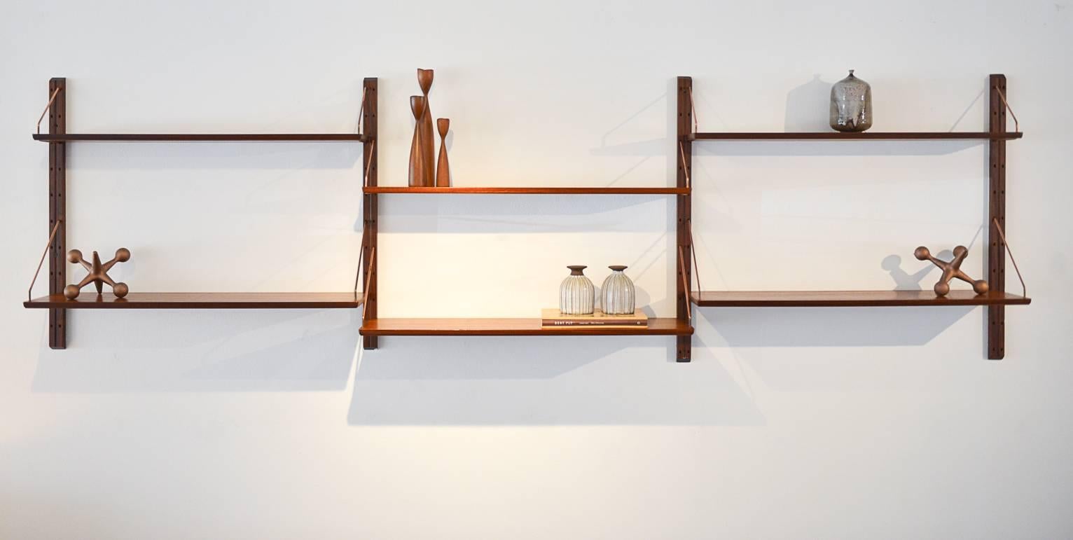 Rare teak shelving unit with very unique copper-plated hardware. Unit includes 7 shelves (one not pictured here) and all hardware. Easy to mount and install, shelves are fully customizable and can be adjusted any way you like.

As shown, measures