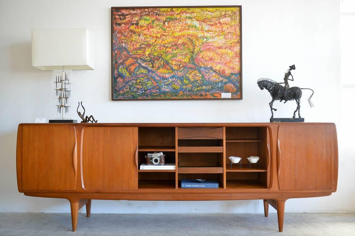Rare large teak credenza model 19 by Johannes Andersen for Uldum Mobelfabrik, circa 1955. Tambour doors on inner, hinged doors on outside and an abundant amount of storage on inside with adjustable shelving and sliding drawers. Curved sculpted