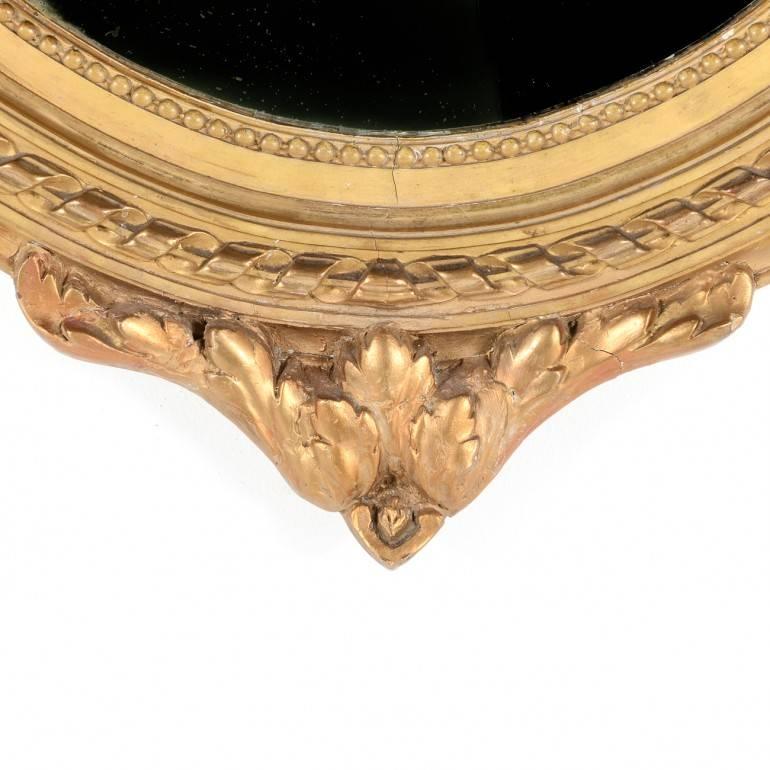 Classic French Louis XVI gilt gesso and wood, oval framed mirror in original condition. Classic ribbon design.
