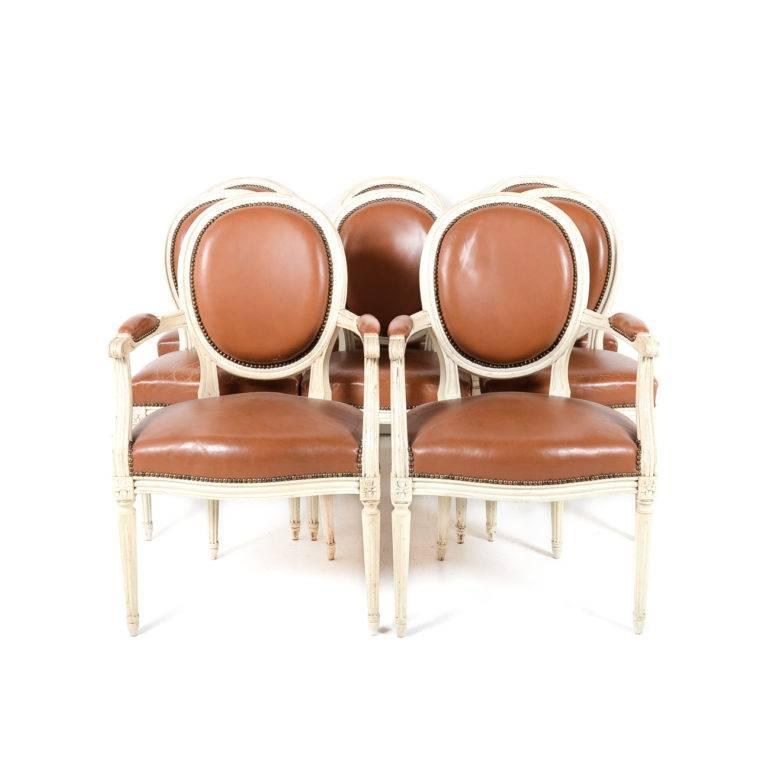 A set of originally painted French Louis XVI cameo-back chairs with original saddle-colored leather. Seats are distressed but still very attractive. Structurally sound. 


