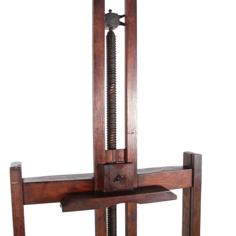 This authentic 19th century solid oak French wood easel was imported from France and is still in functional condition with all its original hardware. The gear mechanism is solid carved wood and it slips a little when lowered or raised, due to its