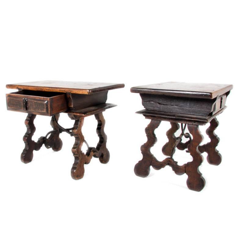 Highly decorative and rare, this pair of Italian solid walnut nightstands have decorative wrought iron stretchers and great patina.
