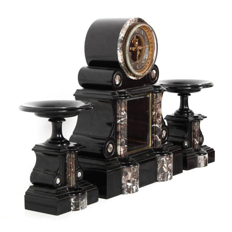 An extra-large, solid onyx-and-marble Napoleon III mantel clock from Paris, of impressive quality. Professionally-serviced and in good running order. Measures: Clock: 15″ wide x 6″ deep x 19″ tall; each side piece: 7″ wide x 4″ deep x 10″ tall.
 