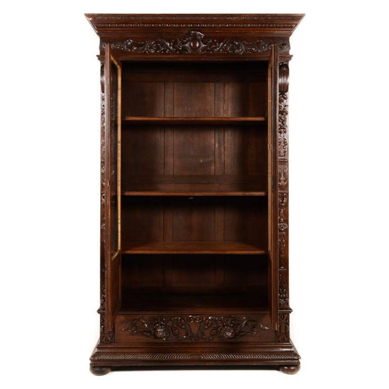 Exceptional antique 19th century French Renaissance Revival bookcase, with beautiful carving and detail on solid hand-carved oak. This piece was originally commissioned by an artist - a painter to be exact - evidenced by the pallet and brushes,