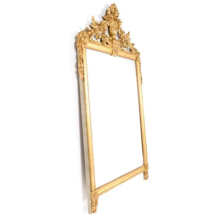 Italian neoclassical style hand-carved mirror of superior quality. Giltwood frame adorned with flowers and swags. Mid-20th century production.
 