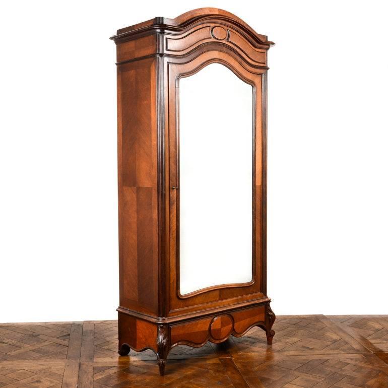 Antique French walnut single-door armoire. Circa 1880.
Original bevelled mirror, and fitted, adjustable shelves in the interior.
One ‘hidden’ drawer in skirt of piece; another small drawer inside.
 