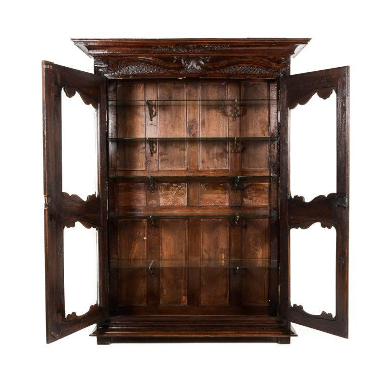 Rare antique French carved oak vitrine, converted from an 1820s armoire with hand-bevelled glass panels in place of the original wood. Complete with beautiful 19th century shelf brackets. A stunning and unique piece. Its shallow depth makes it very