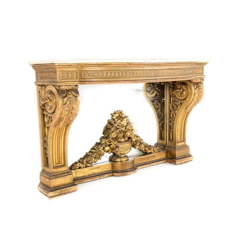 Important antique Louis XVI solid hand-carved giltwood-and-marble top console. The legs carved with swags and flora with a central carved urn with flowers, circa 1780.  

This console originated from thr Chateau D’Haroue as a part of the collection