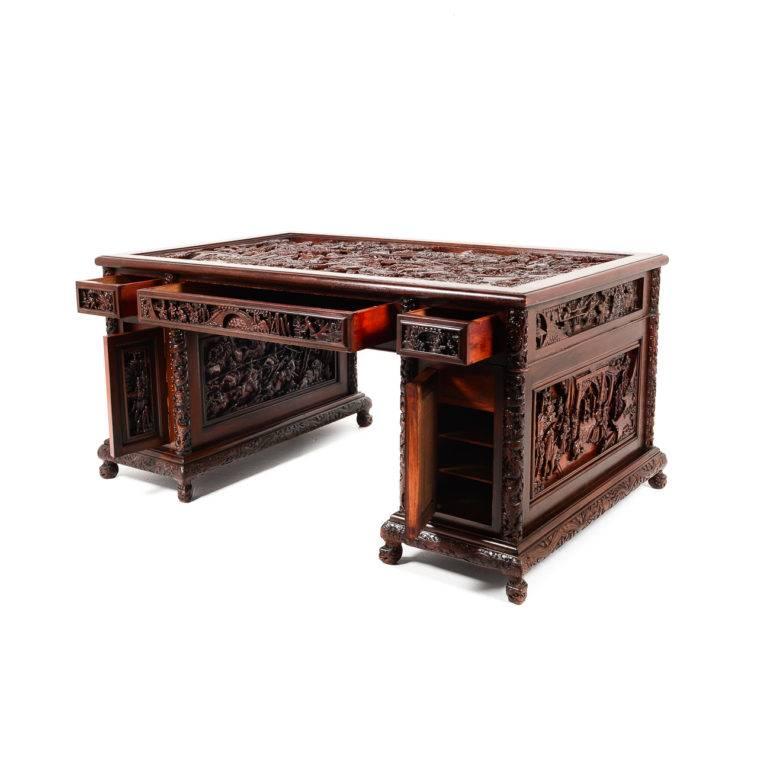 Monumental antique Chinese hardwood desk. These desks were made in China specifically for export to the West. This piece is of elaborately carved hardwood, with detailed depictions of warriors in battle, circa 1910. Would be an imposing piece in an