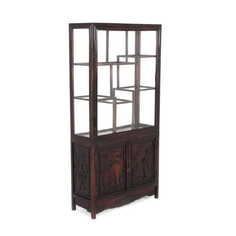 Antique Chinese display cabinet in Hong-Mu wood (or rosewood), with nicely-carved panels. From the late 19th-early 20th century. A shallow depth makes it a versatile piece throughout the home, with the shelves and the front and back panels all of