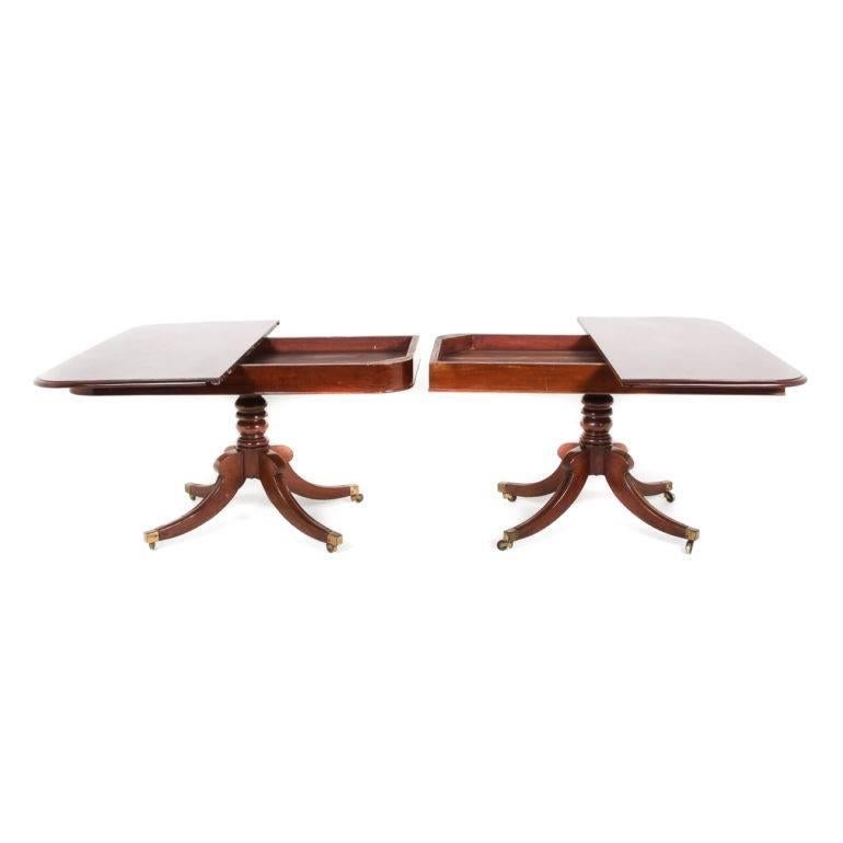 An unusually designed, eight-foot-long William IV mahogany dining table, with two leafs. The two ends of the table may also be used as a pair of console tables. Circa 1840.

Each console tabletop rotates 90 degrees to allow the base to support the