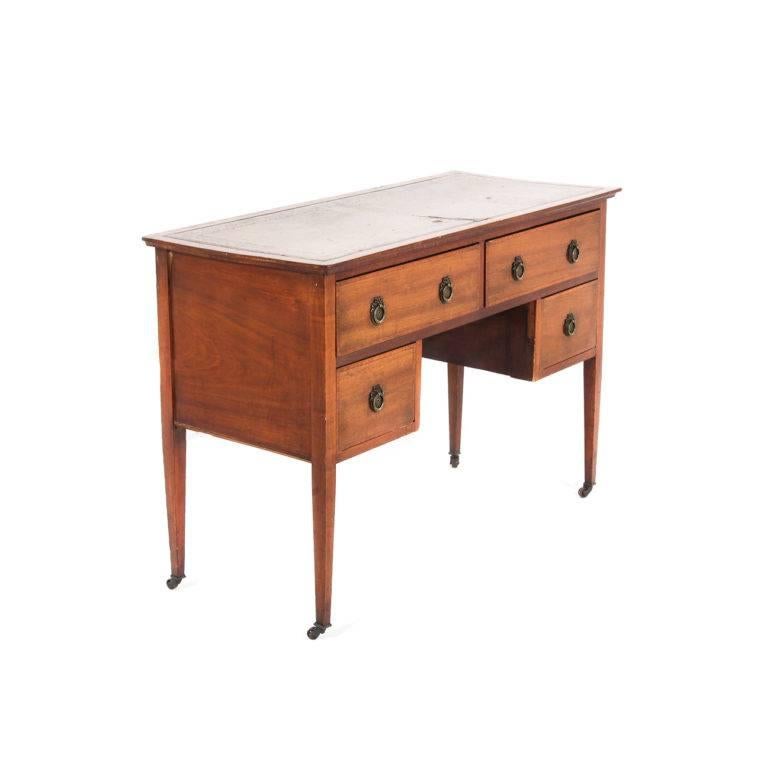 Small, inlaid and banded, leather-top desk. The wood detailing is very nice on this piece. Its smaller size makes it a good candidate for many different rooms in the home, even the kitchen, Circa 1930, with original castors.

   