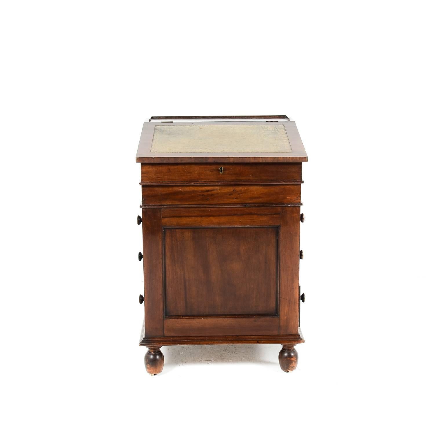 Antique English mahogany Davenport desk with sliding top. Provenance from the Vancouver Dueck family.

Fitted with four large drawers, a small pen and ink drawer, two pull-out slides, and two small fitted interior drawers.

On bun feet with inset