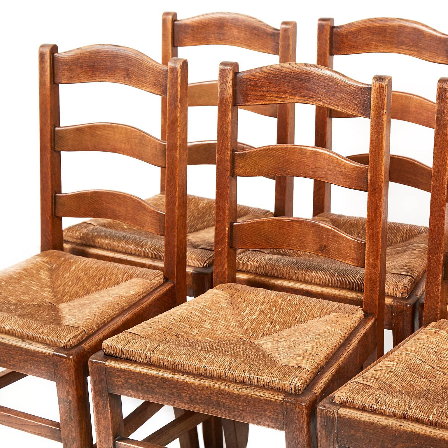 A sturdy set of oak rush-seat French ladder back chairs. Removable ‘drop-in’ seats to allow for re-gluing of chairs if required in the future and the potential for changing to upholstered seats. Comfortable and robust chairs, suitable for everyday